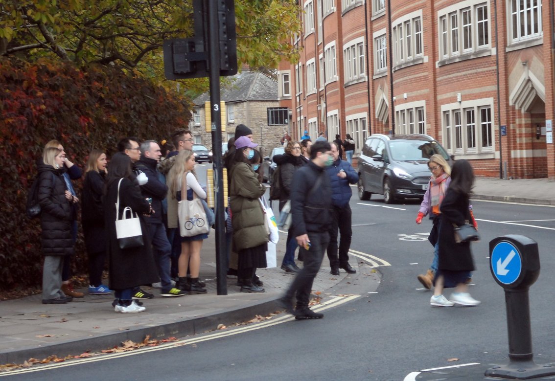 Pedestrians crowded on pavement and trying to cross road at corner of Worcester Road, Oxford