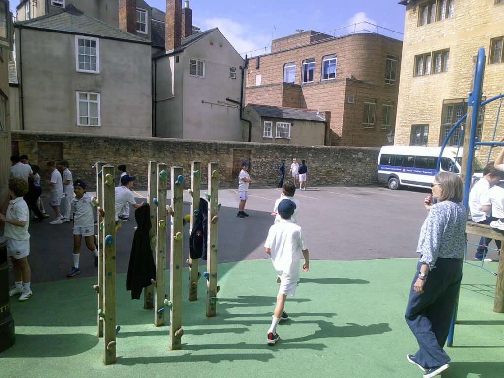 Children dressed in white in green paved school playground