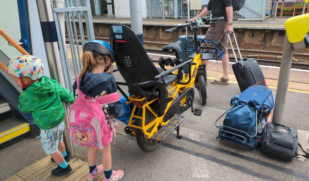 Two children, bike and bags on railway platform